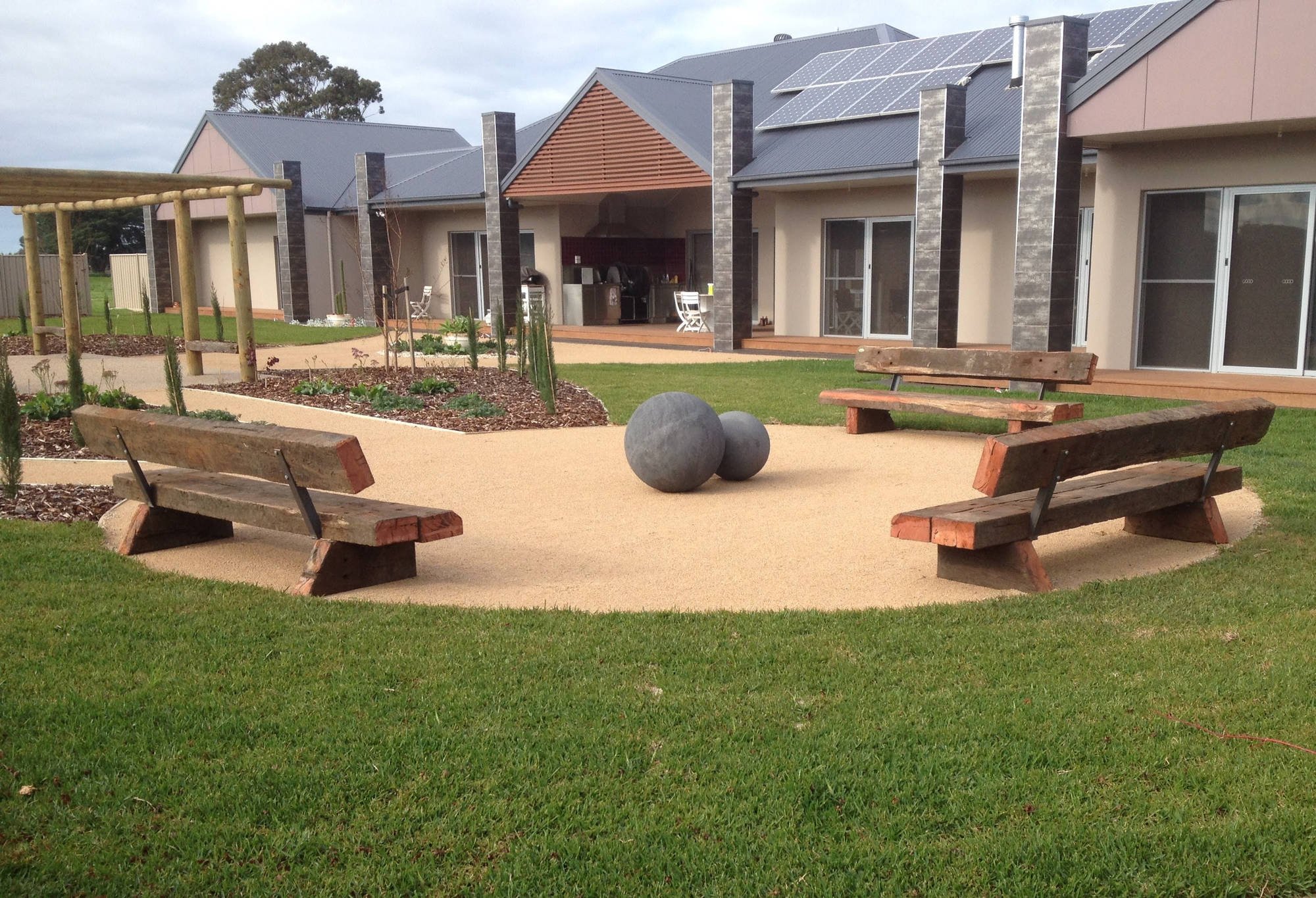 Handcrafted Australian hardwood sleeper bench seats in a residential courtyard garden